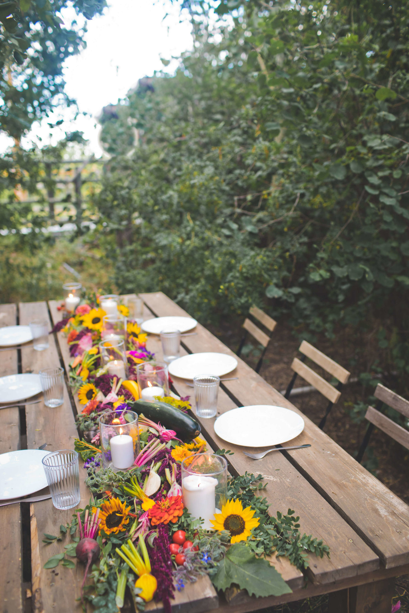 A wooden table adorned with flowers and plates, perfect for farm weddings and events.