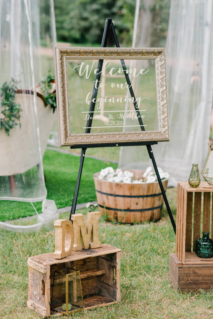 outdoor wedding decor with wood crates and a picture frame sign. https://www.thegathered.ca