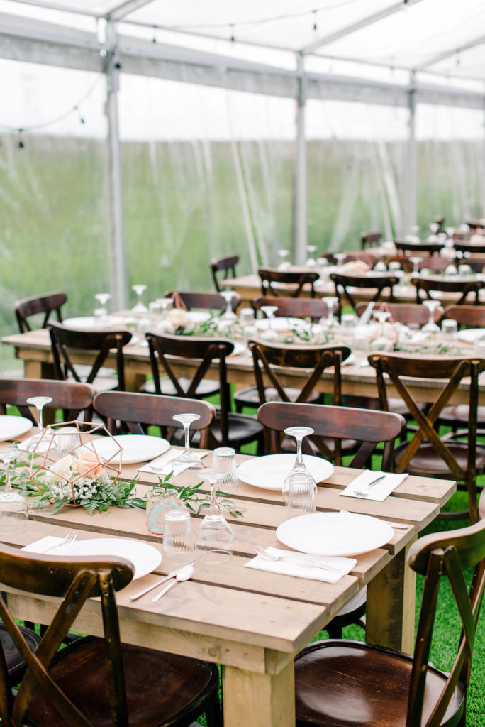 clear transparent tent at a calgary alberta wedding venue complete with cross back chairs and wood harvest tables! https://www.thegathered.ca
