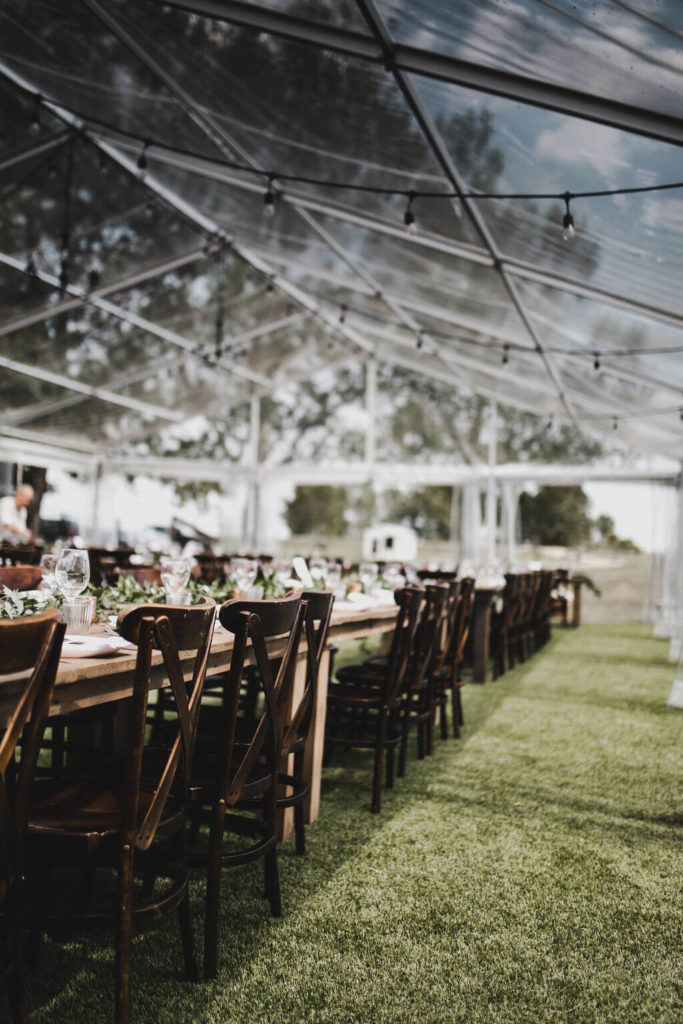 Rustic Outdoor farm wedding with wood harvest tables and crossback chairs https://www.thegathered.ca