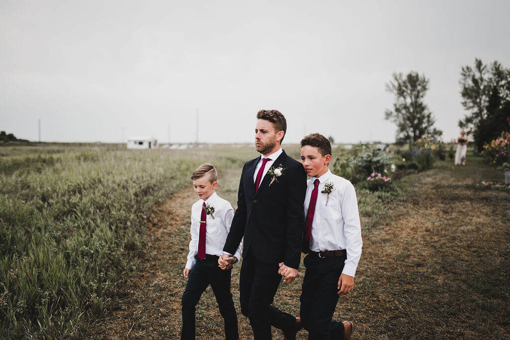 wedding ceremony procession with groom and his sons https://www.thegathered.ca