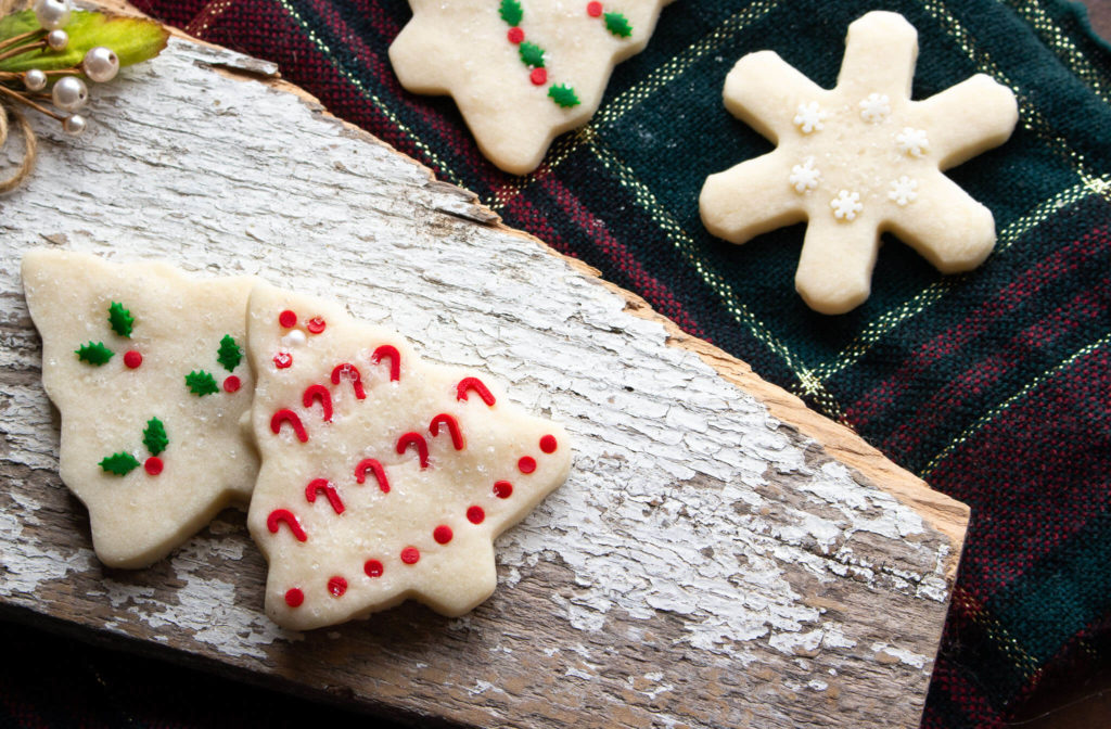 christmas and star shaped shortbread cookies with a christmas theme, red and green sprinkles on cookies