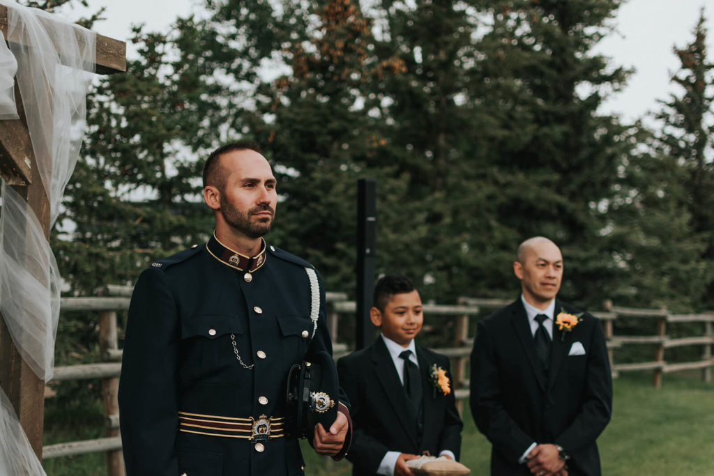 groom waiting at the alter with with groomsmen beside him 