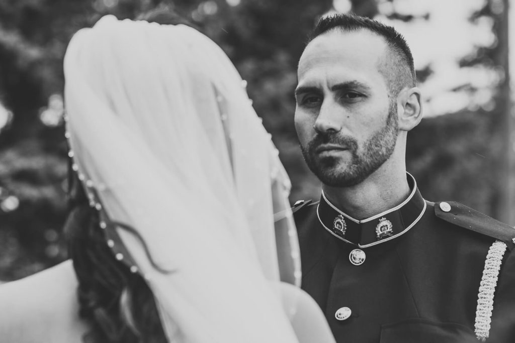 black and white image of grooms face during the ceremony