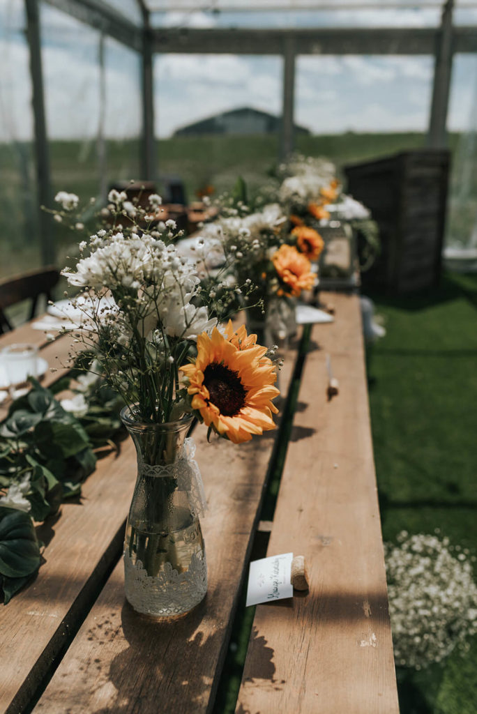 sunflowers and baby's breath centrepieces on wood harvest tables 