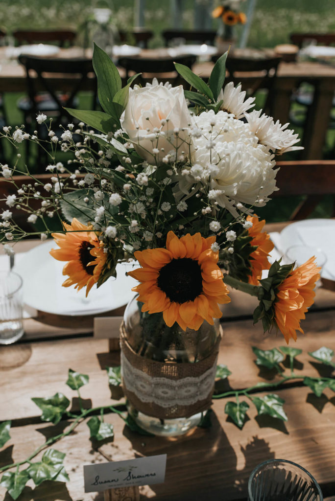 floral centrepiece filled with sunflowers, baby's breath, and white flowers