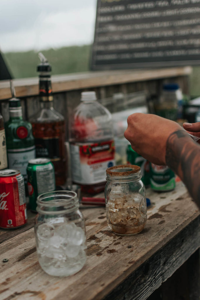 bartender making a drink with liquor bottles lined up in a row