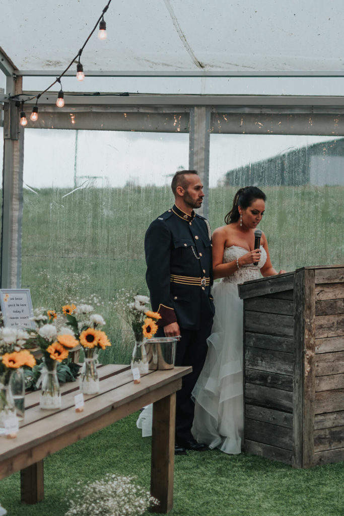 bride and groom standing at a wood podium giving their thank-you speech