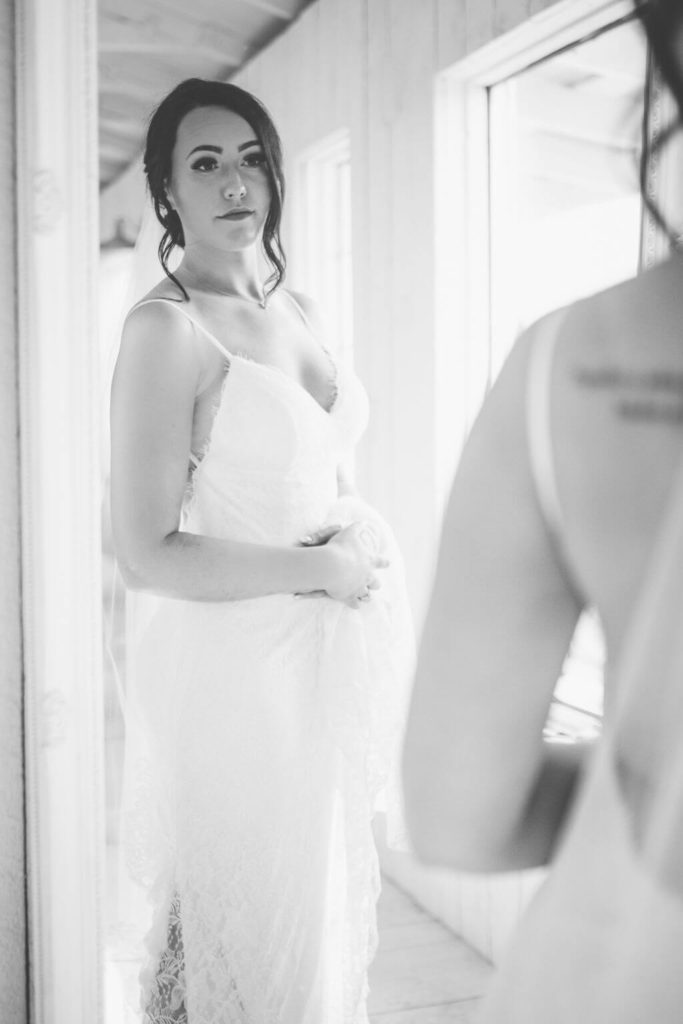 black and white photo of bride looking at herself in the mirror