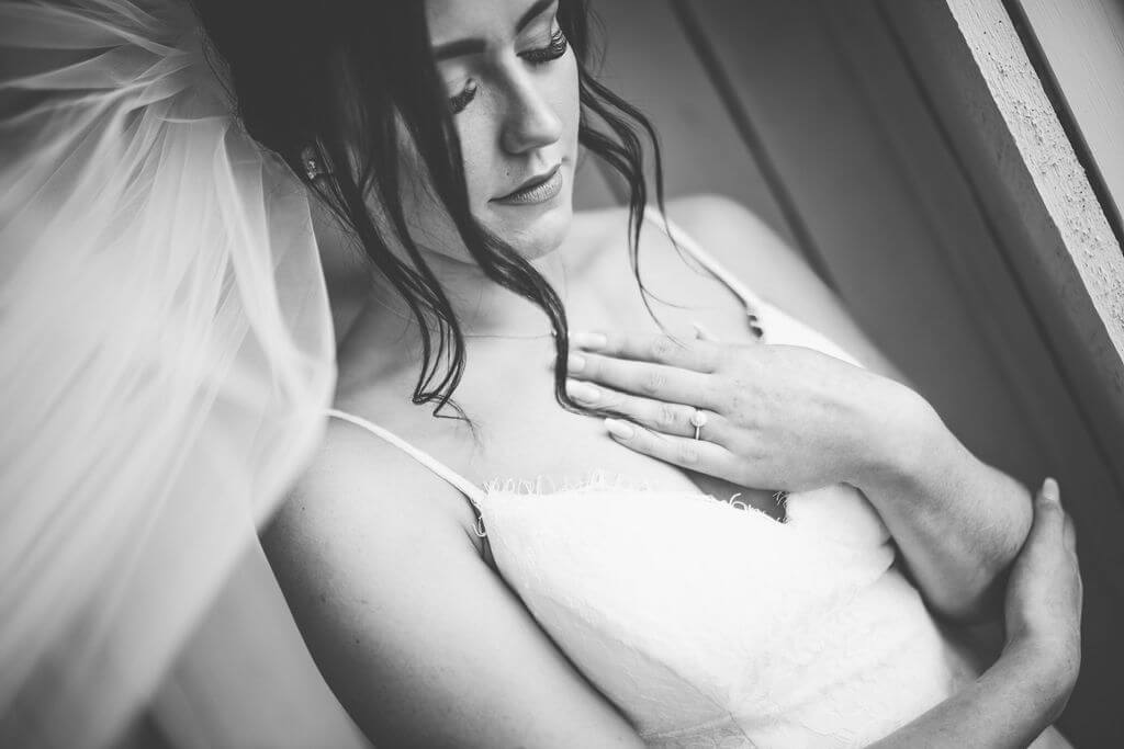 black and white photo of the bride with her hand over her heart