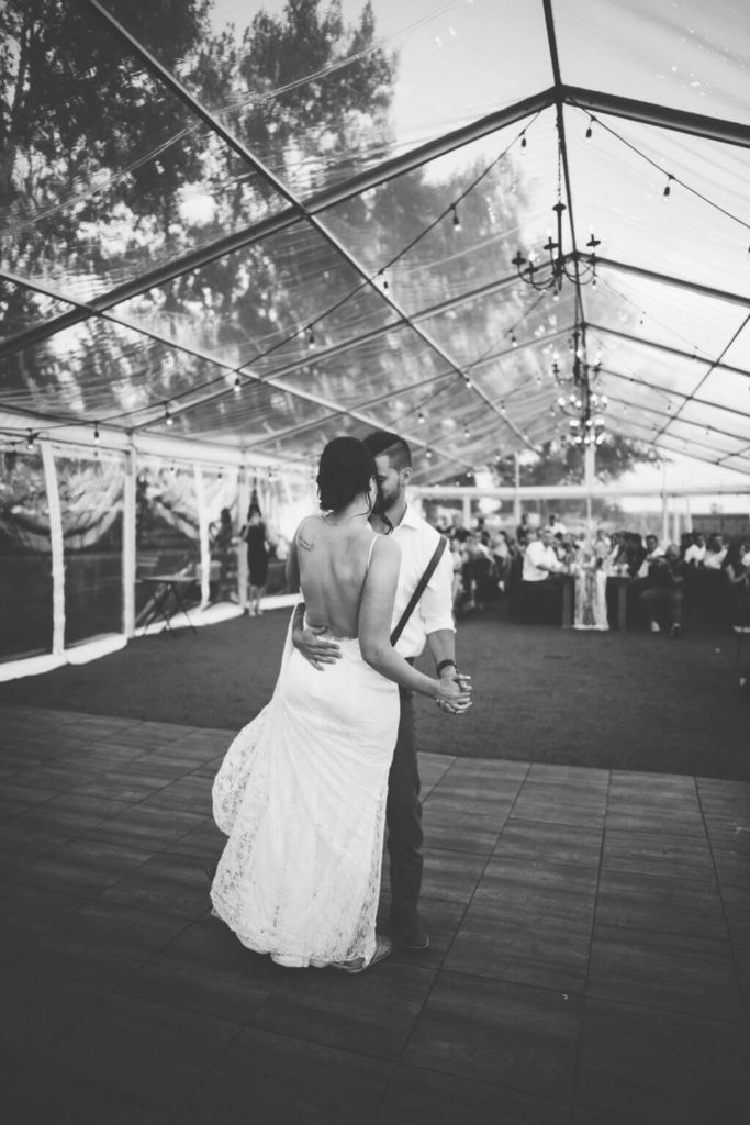 black and white photo of bride and grooms first dance, bride is wearing a low back dress