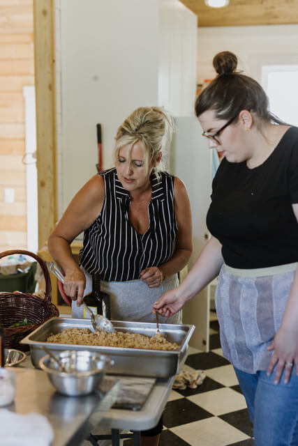 nicole and elaine dishing out a pan of couscous