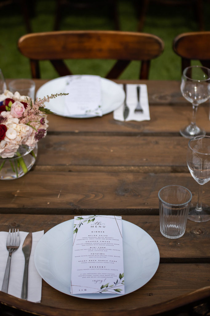 wood harvest table decor with card menus on the plates and blush pink flowers