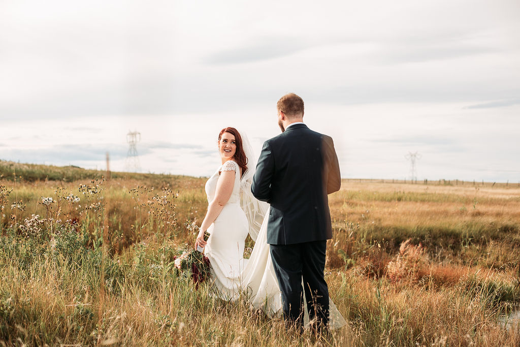 golden prairie fields and overcast sky make the perfect backdrop for this wedding couple at their prairie outdoor wedding. www.thegathered.ca