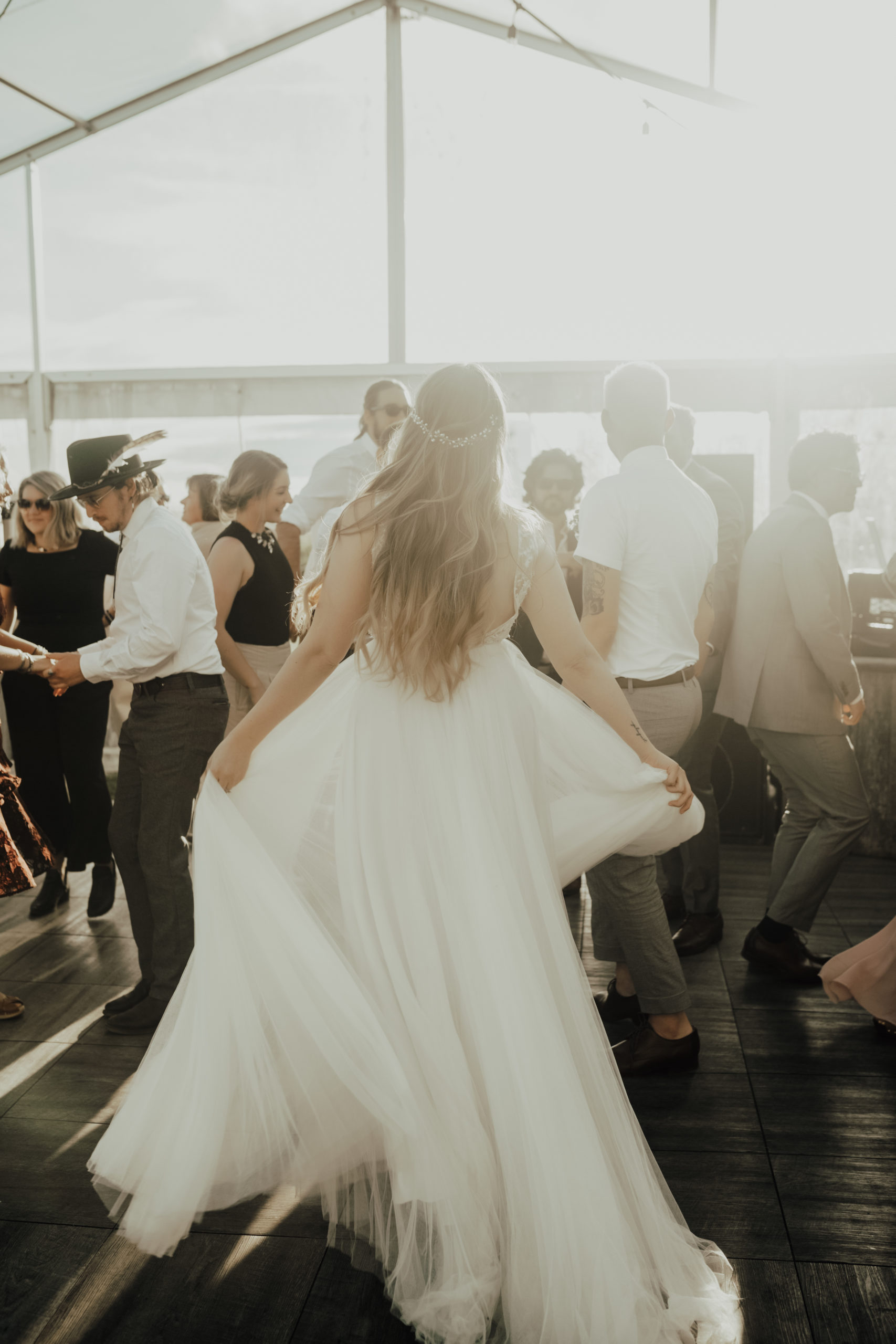 bride twirls her dress on the dancefloor of their outdoor tented wedding venue