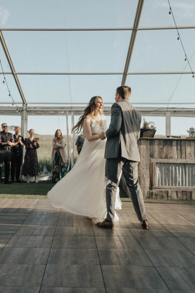 bride twirls with her dress on the dancefloor as the couple share in their first dance at their outdoor romantic wedding.