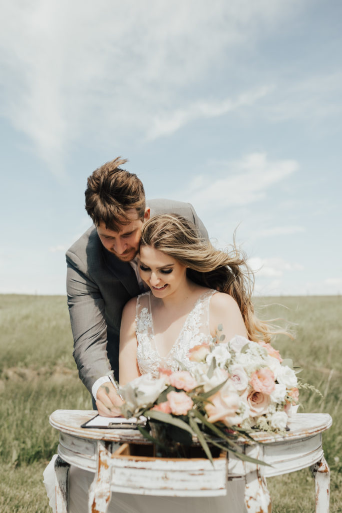 antique white signing table adds the perfect prop for ceremony photos during the signing of the registry for this bride and groom.