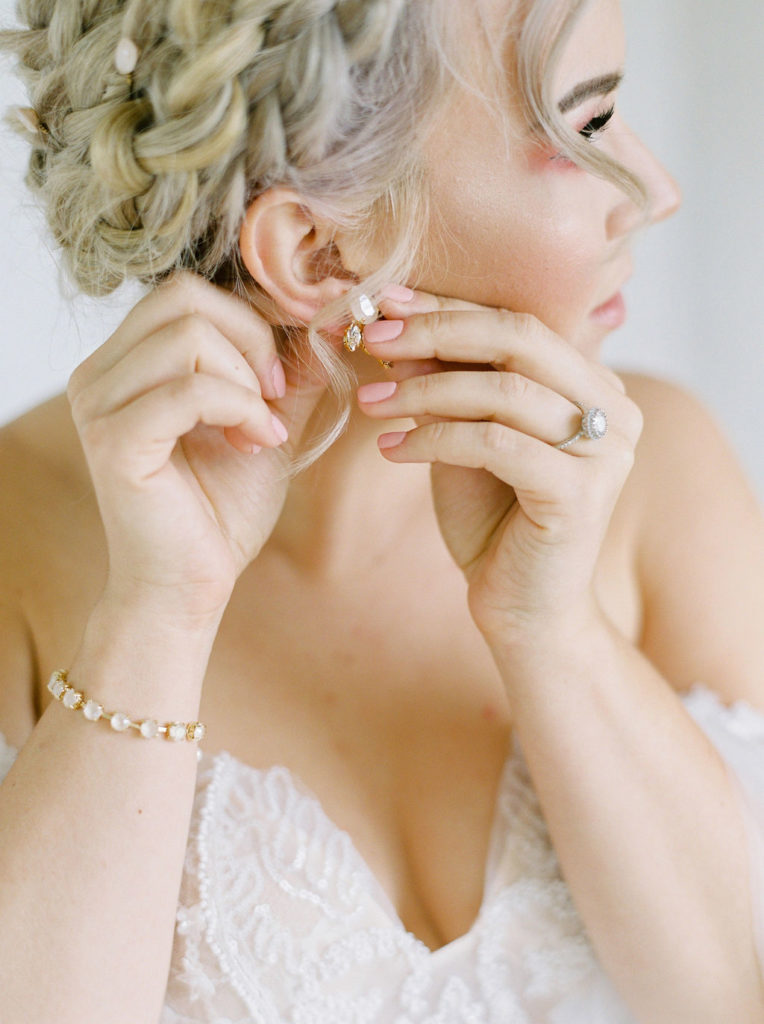 wedding jewelry is a unique way to express your taste, the bride places pearl earrings in her ear