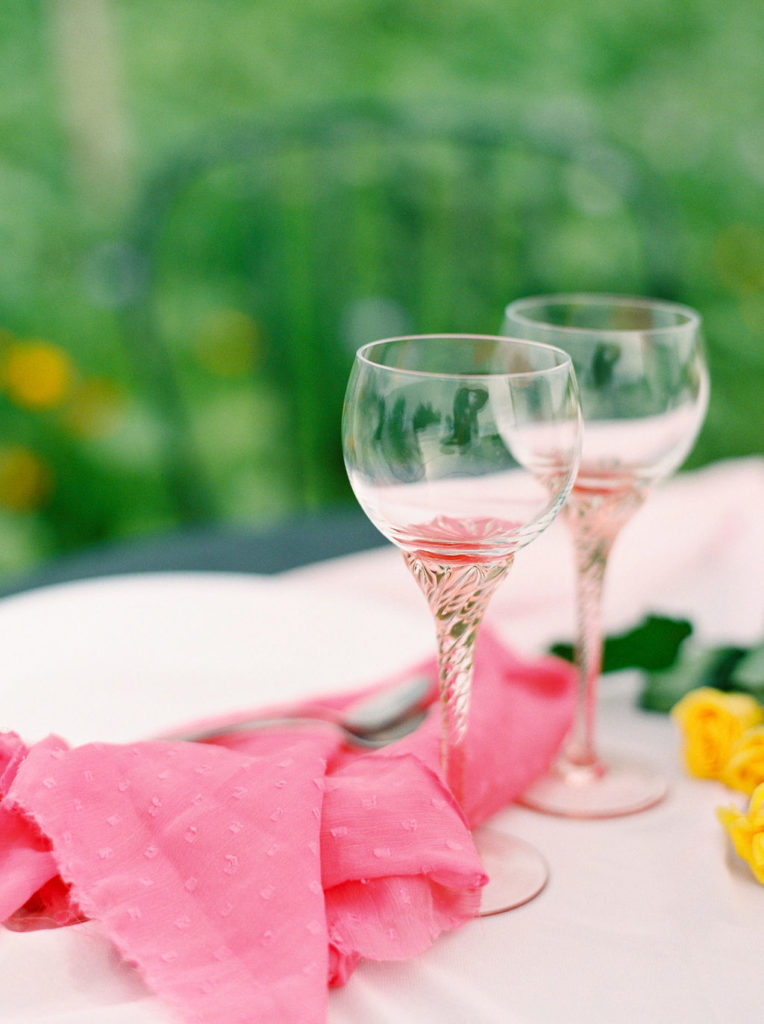 two blush pink wine goblets with pink table cloths and napkins
