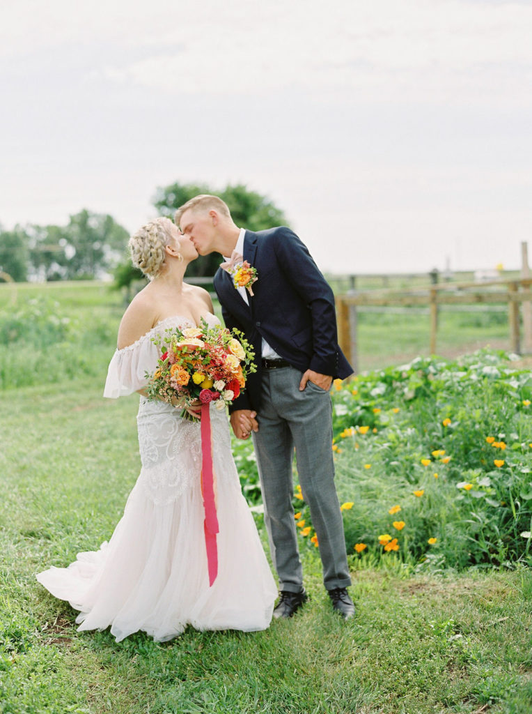 couple kisses in a spring green field
