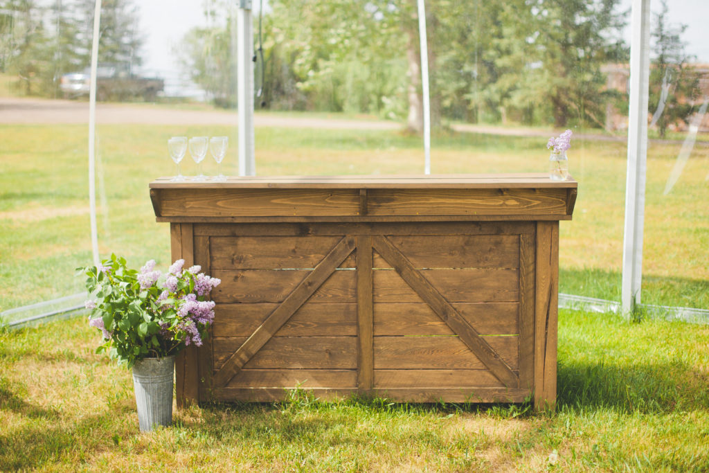 outdoor wooden bar for weddings and events decorated with lilacs as wedding flowers
