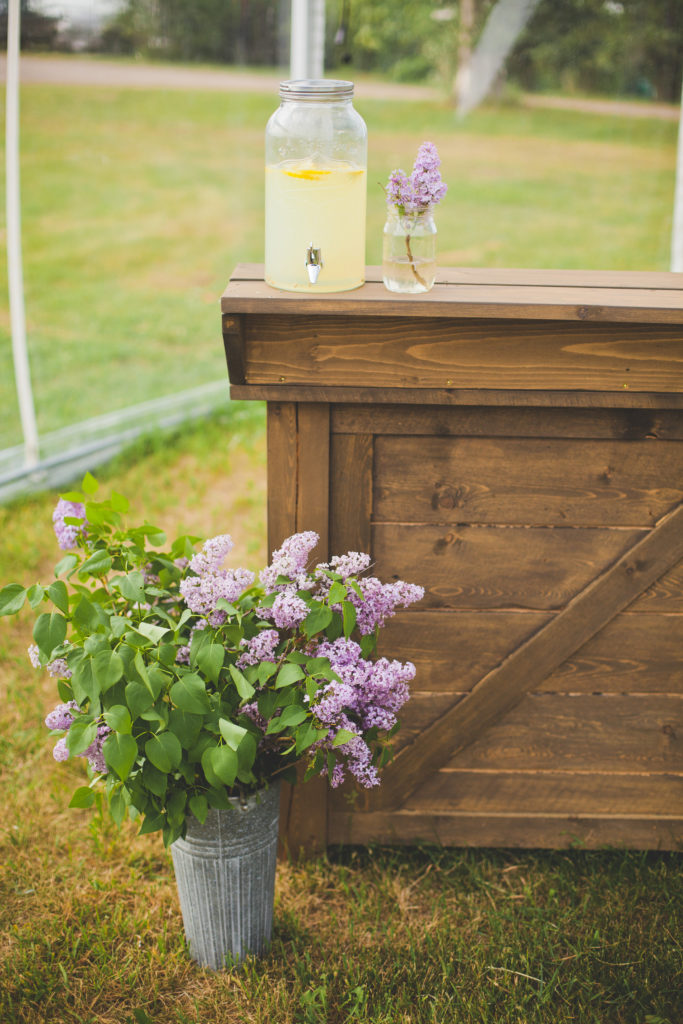 outdoor wooden bar for weddings and events decorated with lilacs as wedding flowers