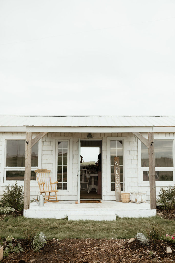 white cottage with a rocking chair on porch