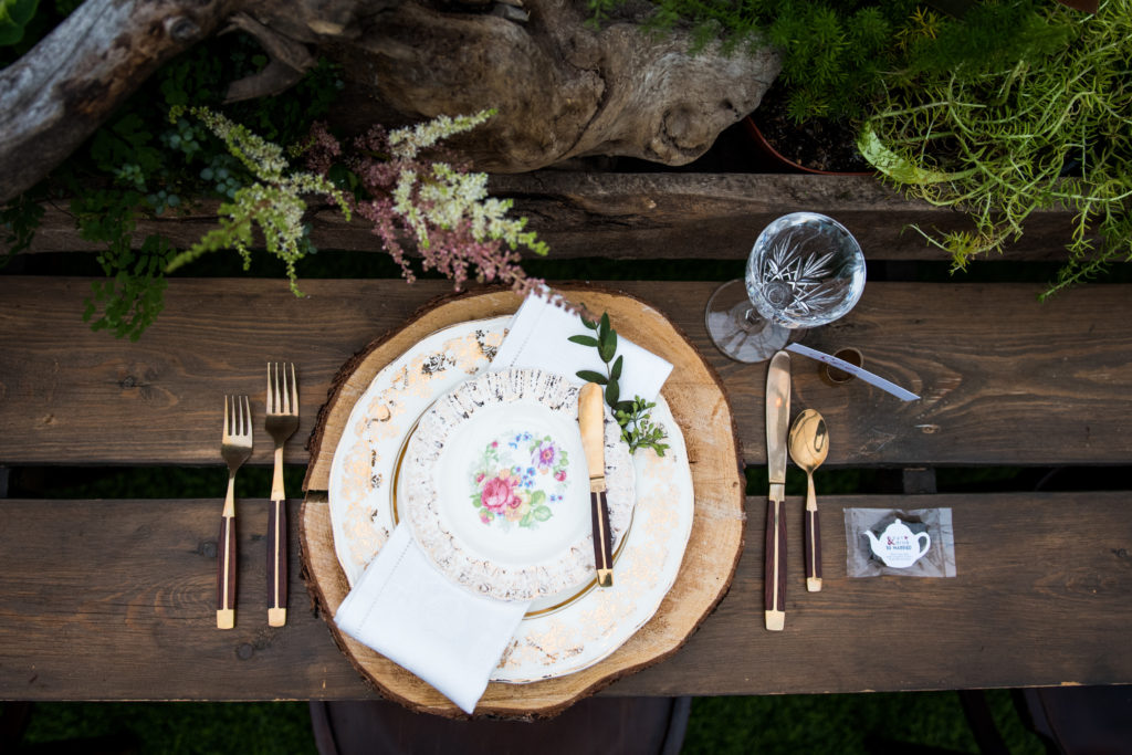 wood placemat with antique china and gold flatware