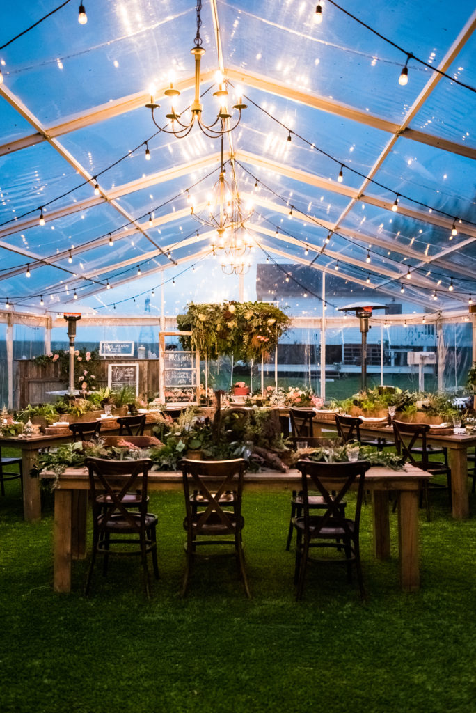 warm glowing lights highlight the clear tent at this outdoor wedding venue thegathered.ca