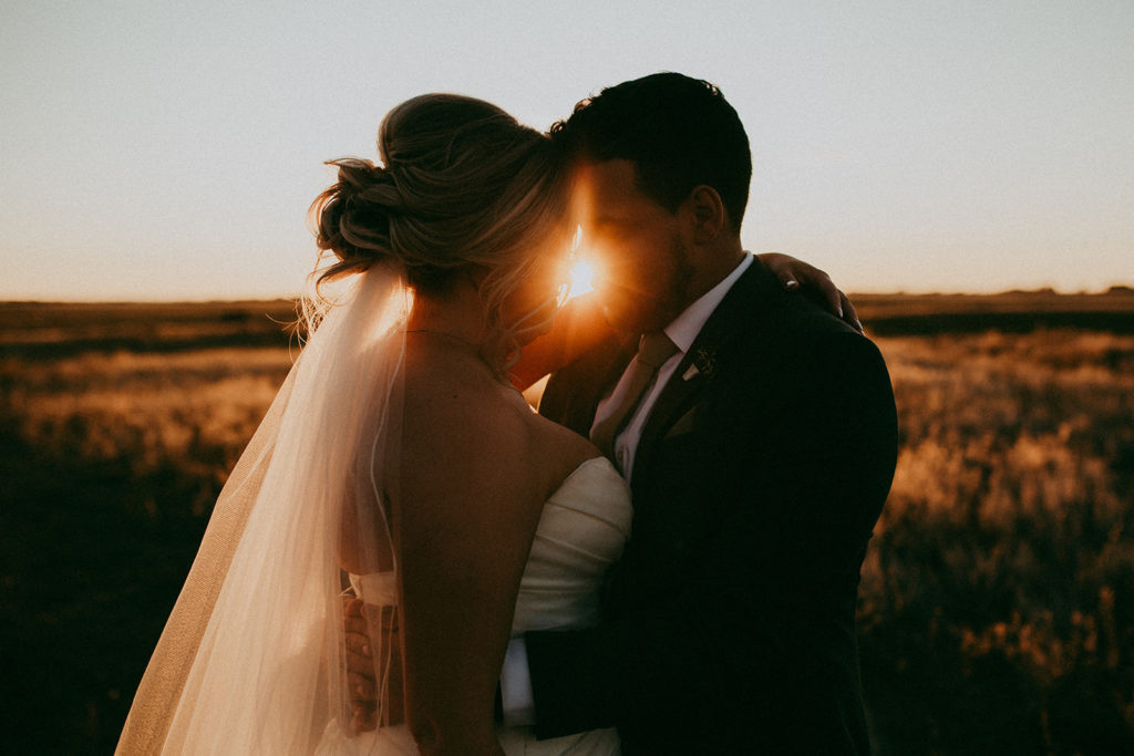 golden hour photos of a bride and groom with their foreheads together