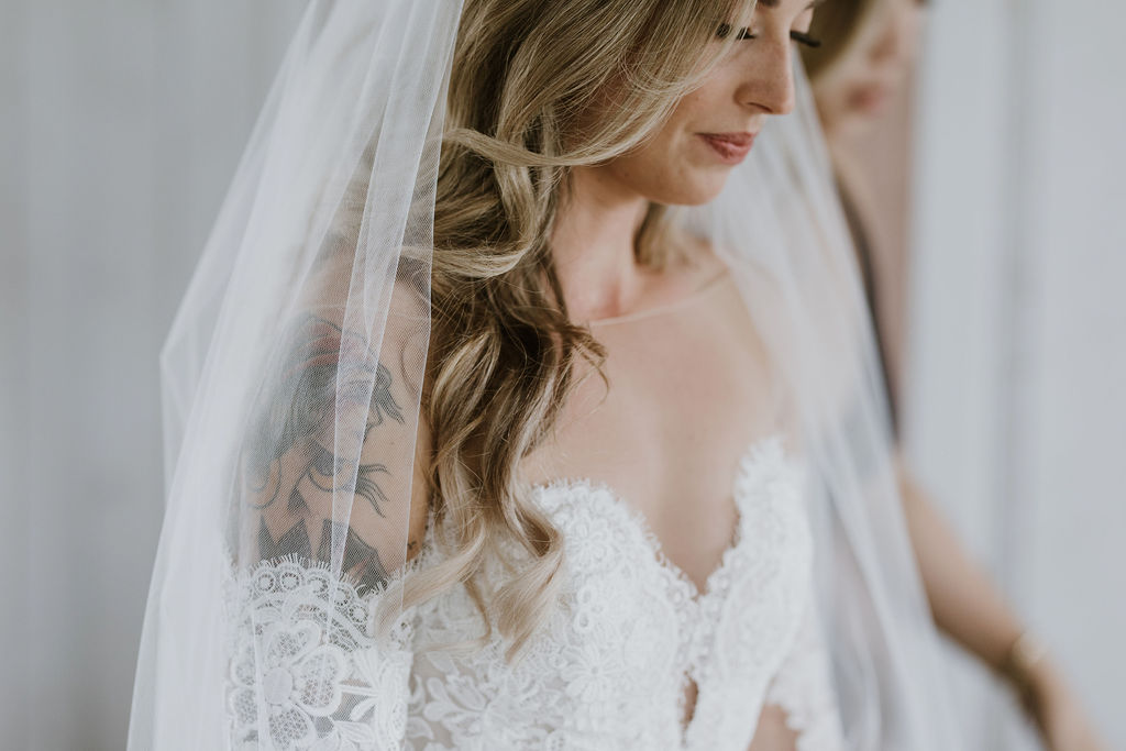 bride with beautiful golden hair and a veil celebrates her day in a white cottage
