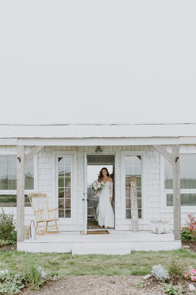 bride walking through the white cottage door of the bridal suite