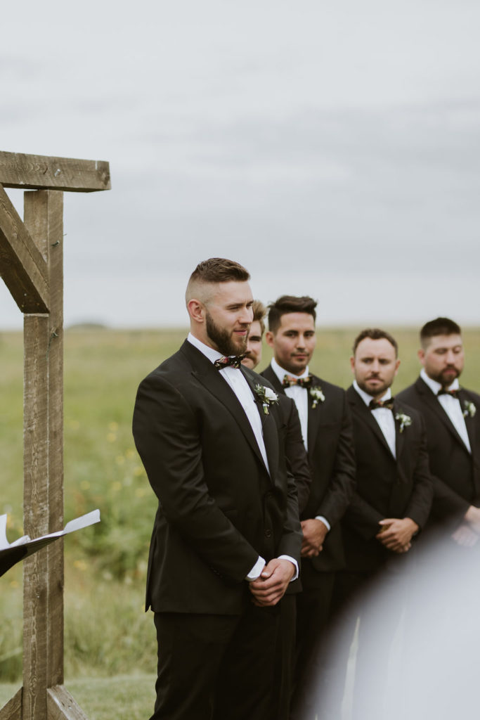 outdoor wedding - groom and groomsmen in a classic black suits