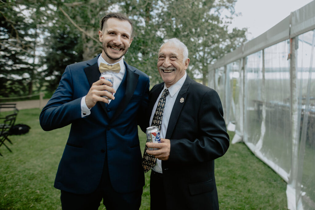 Two men in suits standing next to each other holding ice cream conesunique outdoor wedding celebration