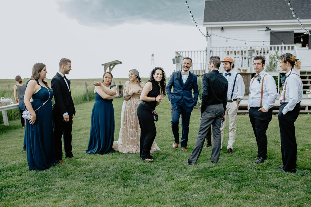 A group of bridesmaids and groomsmen standing in front of a house.