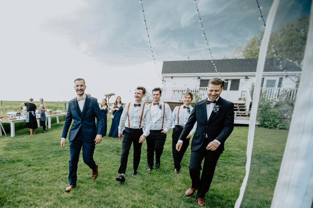 A group of groomsmen walking in front of a house.