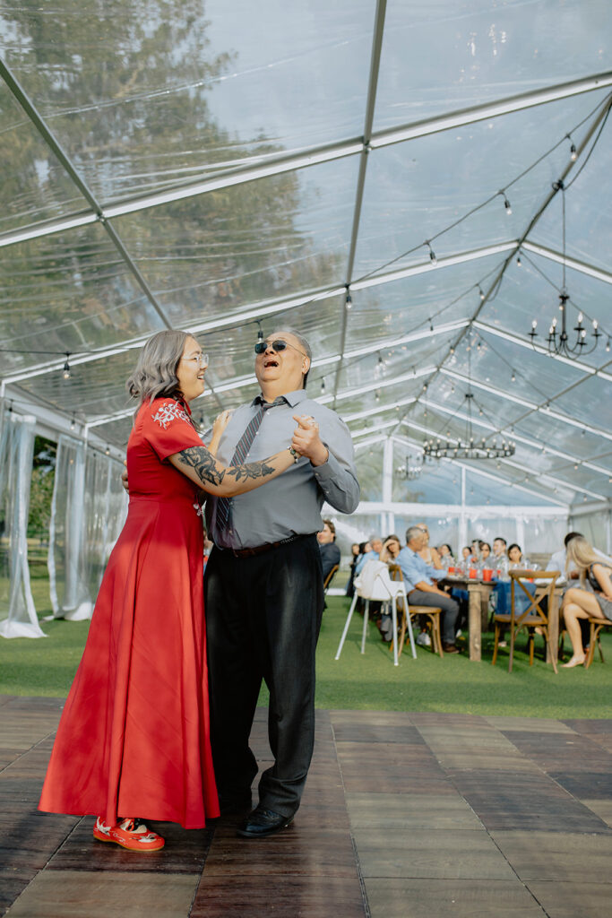 A couple dancing under a tent at a wedding.