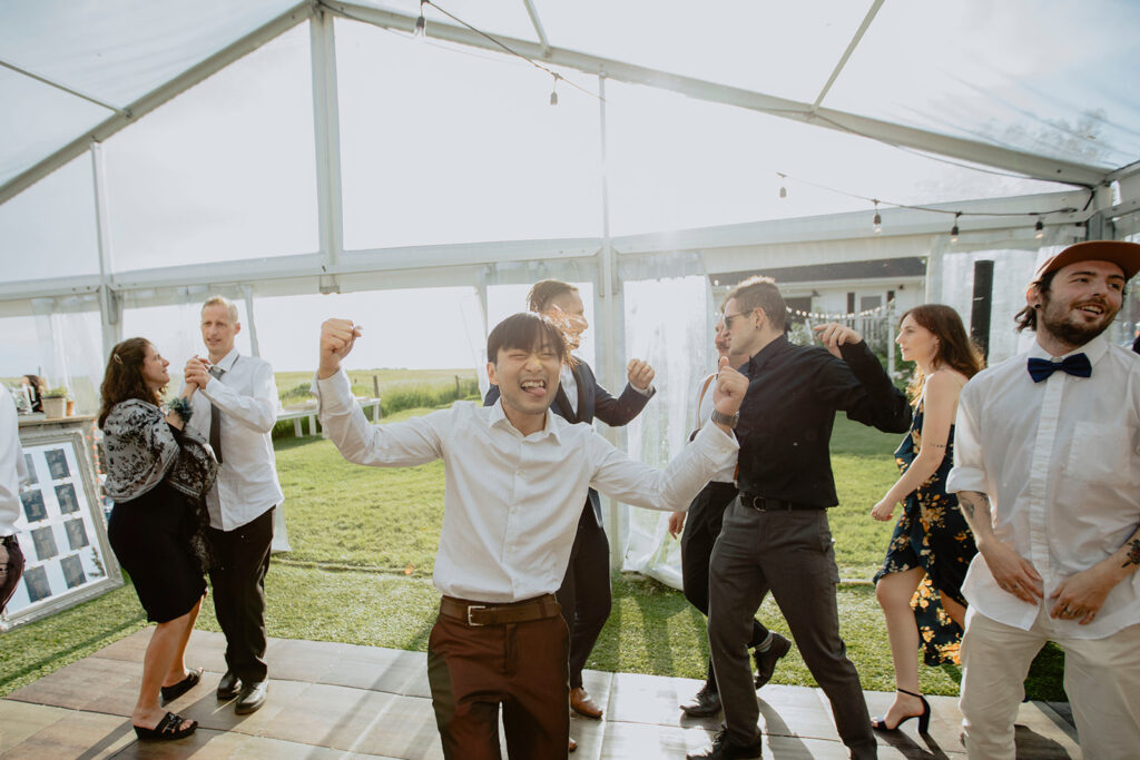 A group of people dancing in a tent.