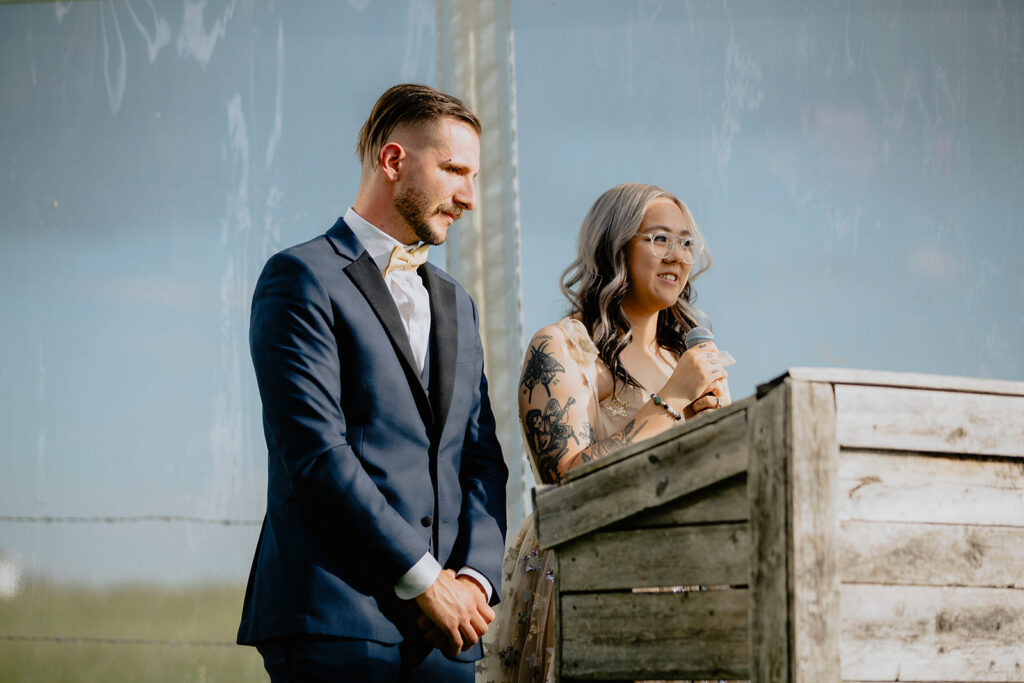 A bride and groom standing at a podium in a field.