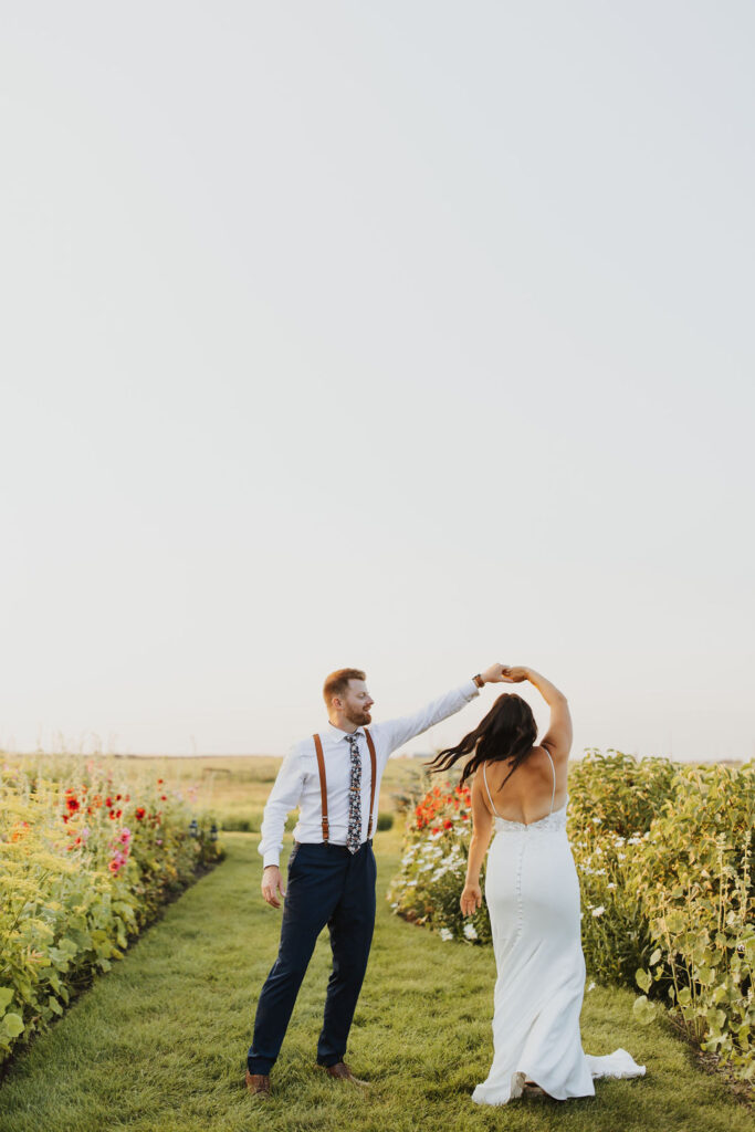 A bride and groom dancing in a field of flowers at The Gathered outdoor wedding and events venue.
