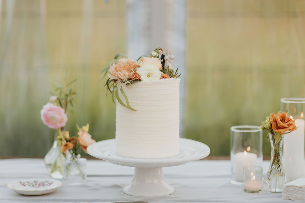 A white wedding cake sits on top of a table.