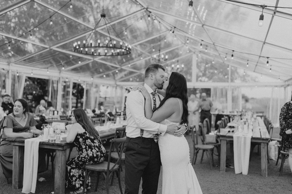 A bride and groom share a first dance in a tent. Enchanting Outdoor Dinner Party.