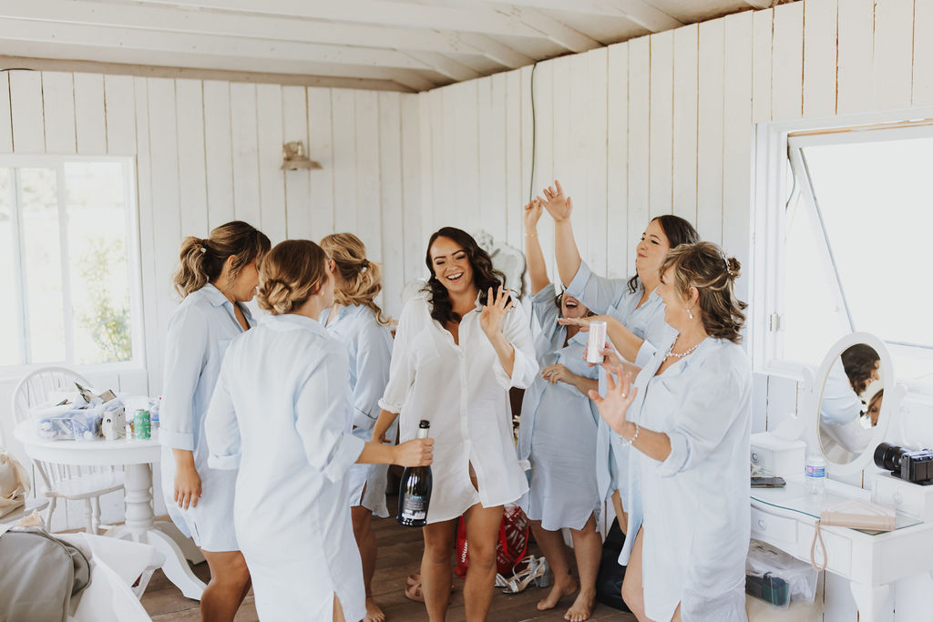 A group of bridesmaids celebrating in a room.