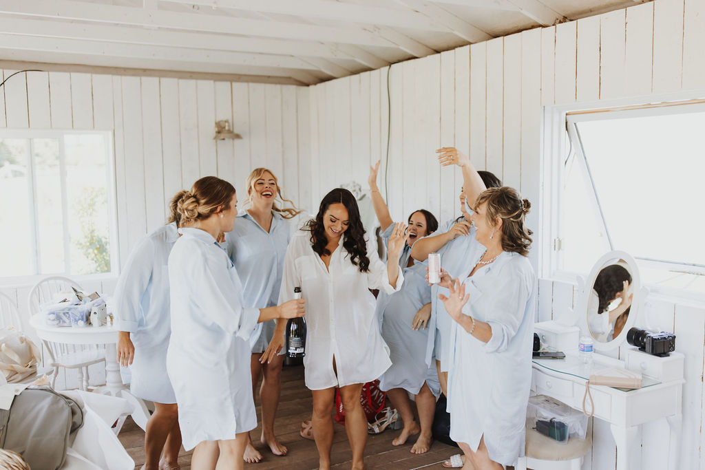 A group of bridesmaids celebrating in a room.