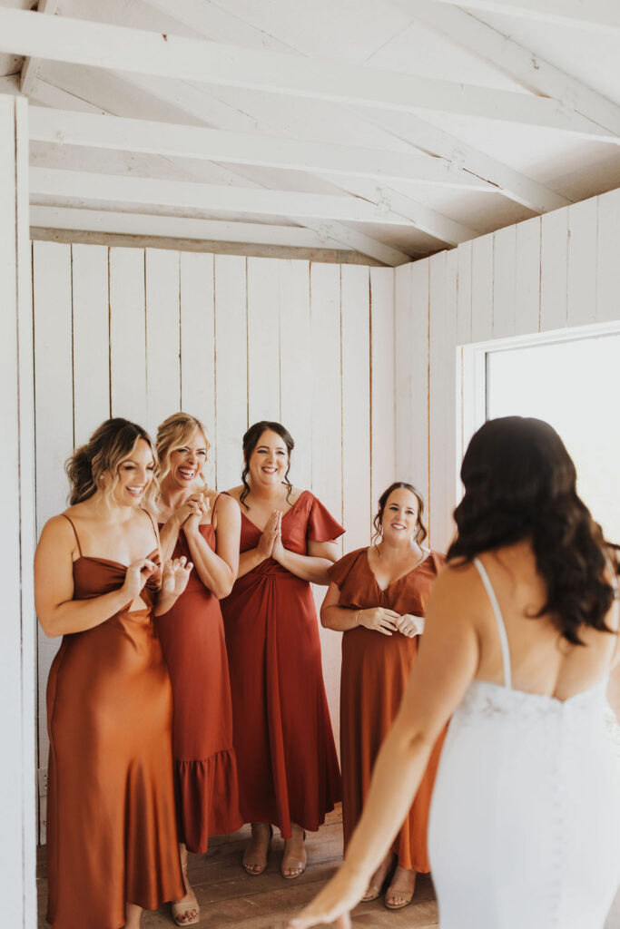 A bride and her bridesmaids in a red dress.