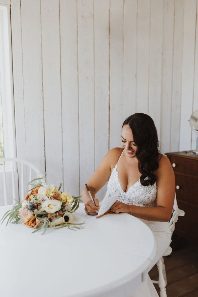 A bride signing her wedding vows at a table.