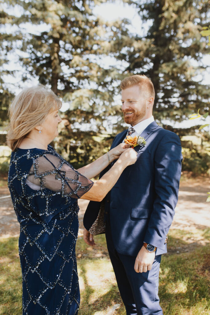 A man putting a boutonniere on a woman.