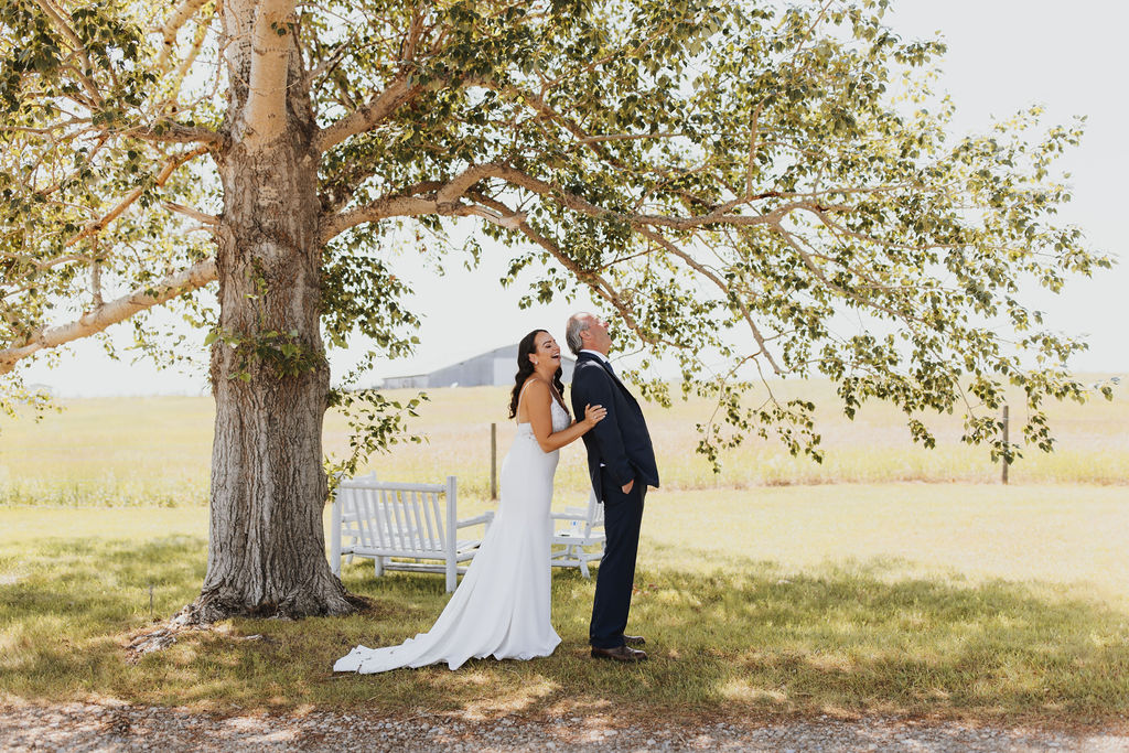 A bride and groom standing under a tree.
