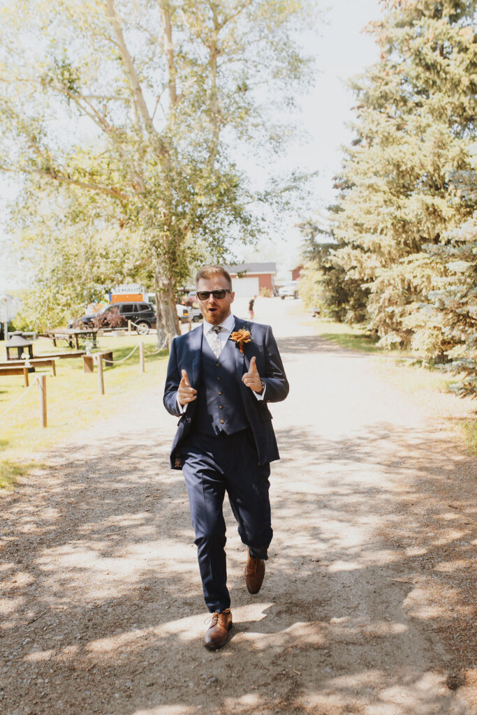 A man in a suit walking down a dirt road.
