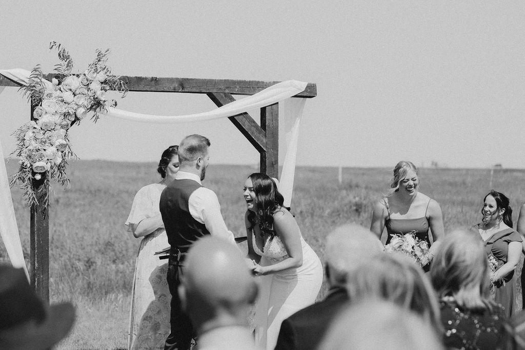 A bride and groom exchanging vows in the middle of a field.